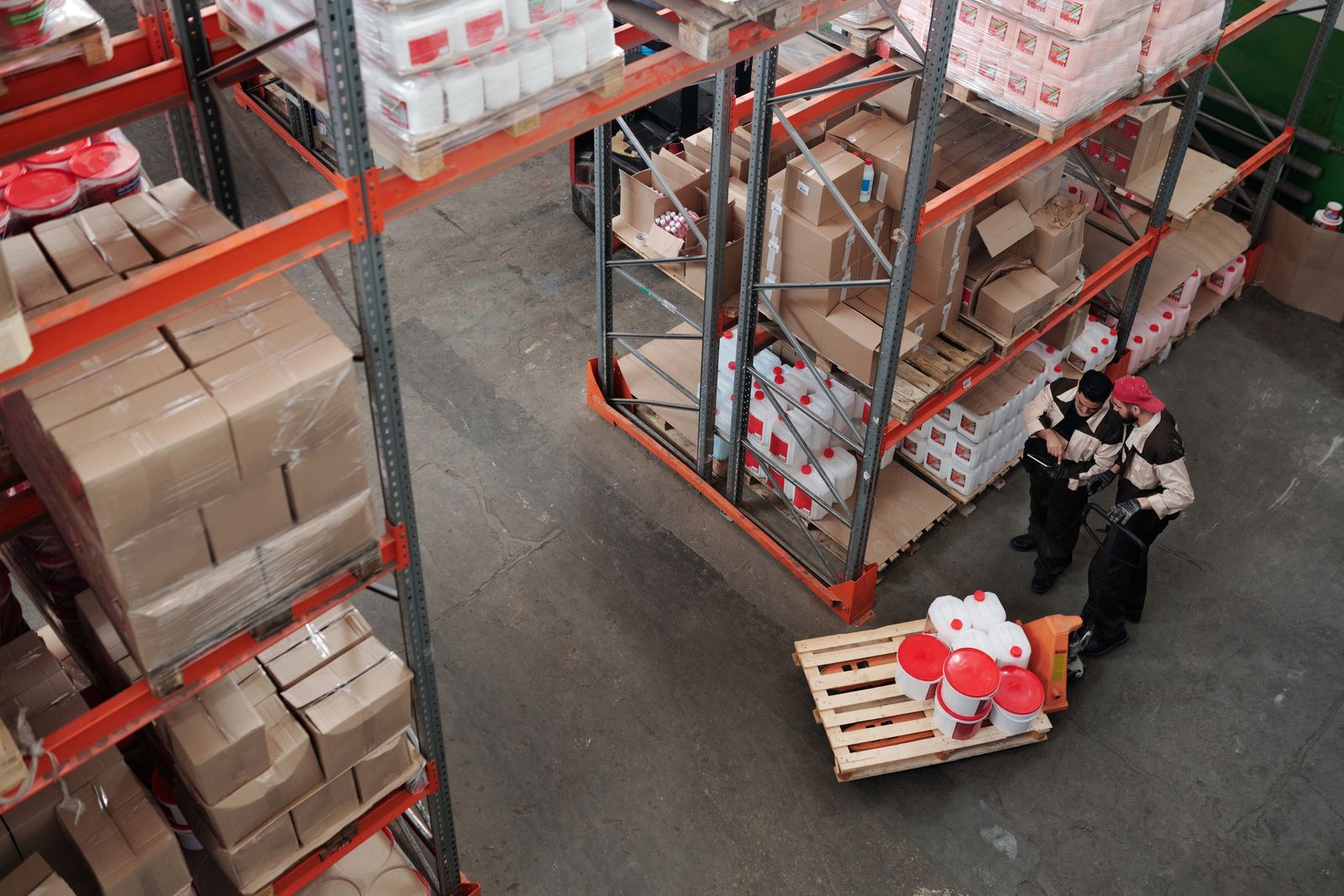 Warehouse colleagues discussing the work among inventory shelves